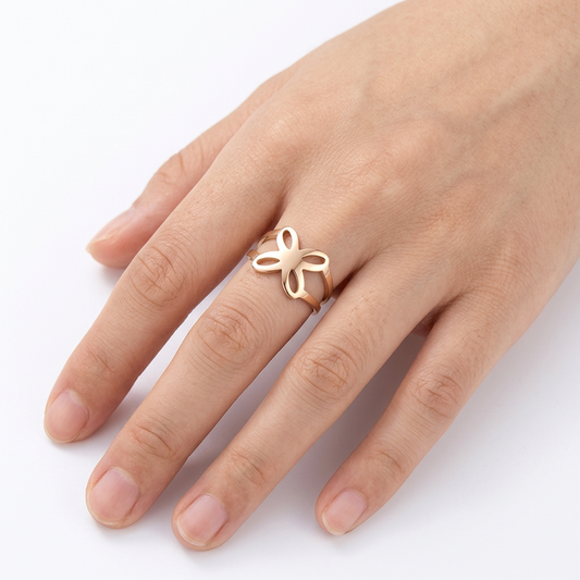 Jeden złoty pierścionek z ażurowym motylem na dłoni modelki na białym tle